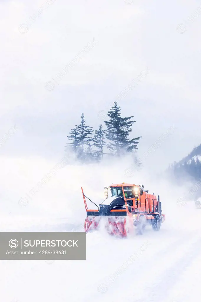 City of Whittier snow removal crew plowing the road to Shotgun Cove after a snow storm, winter Whittier, Southcentral Alaska, USA.