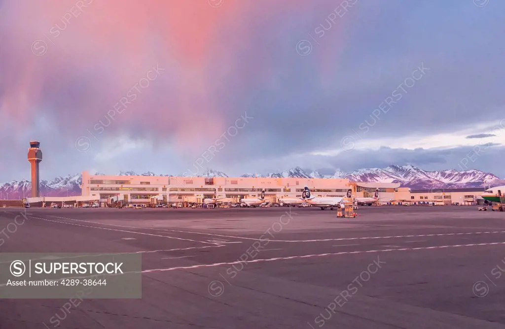 Sunset light falls on Ted Stevens International Airport, view from the Tarmac, early Spring, Anchorage, Southcentral Alaska, USA.