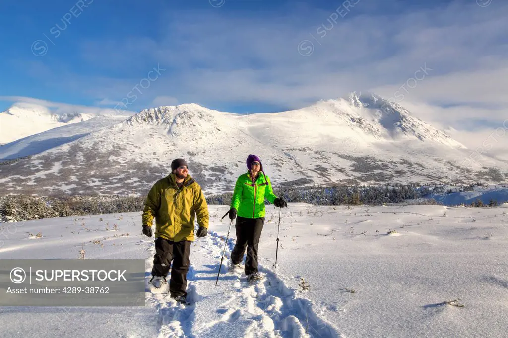 Couple snowshoeing at the Glen Alps area of Chugach State Park on a sunny winter day, Anchorage, Southcentral Alaska, HDR