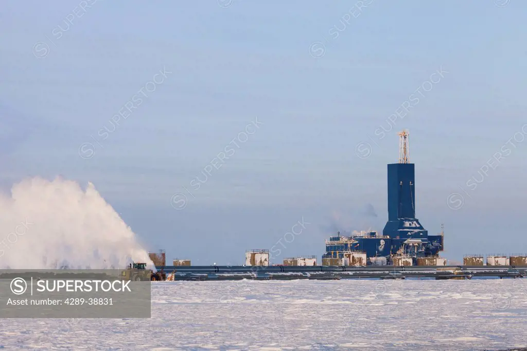 Snow blower removing snow from a pipeline access road with Parker Drilling Rig 273 on Drill Site 2 in the Prudhoe Bay Oil Field, North Slope, Arctic, ...