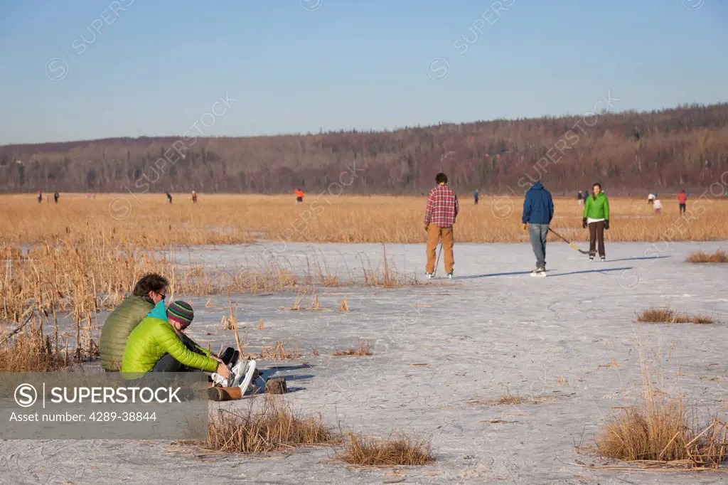 Ice skaters at Potter Marsh after the first thick ice in Autumn, outside Anchorage in Southcentral Alaska.