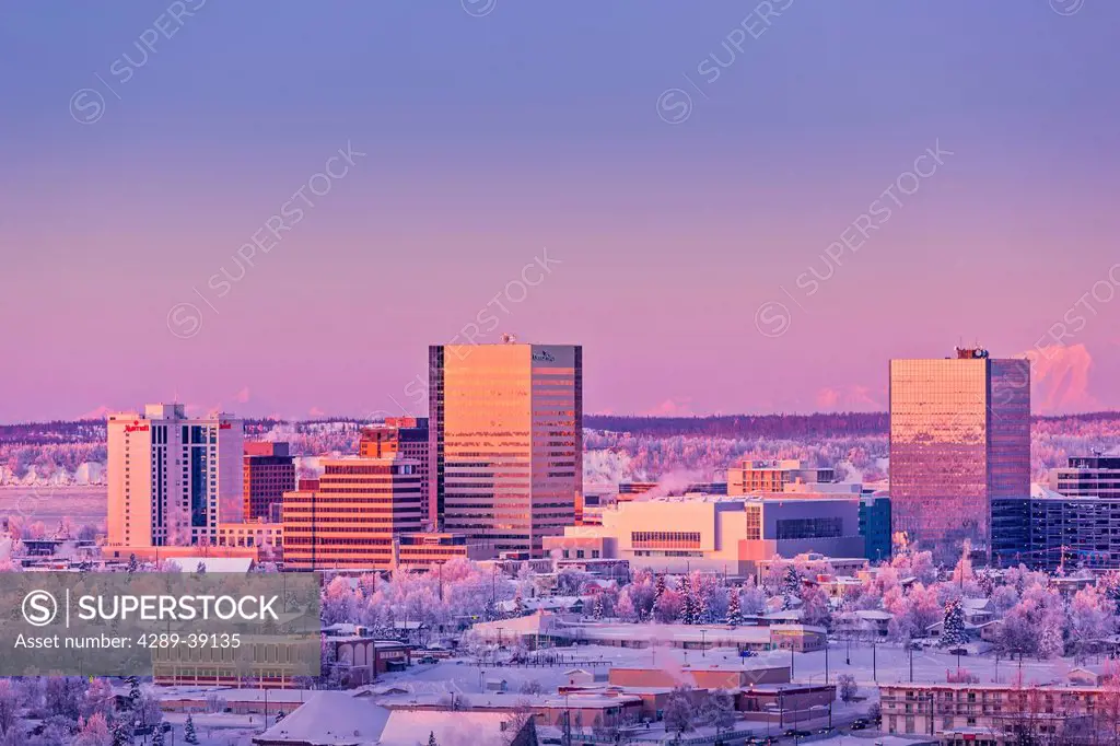 Aerial view of Downtown Anchorage at sunset, Hoarfrost on the trees, Alpenglow on the Alaska Range in the background, winter, Anchorage, Southcentral ...