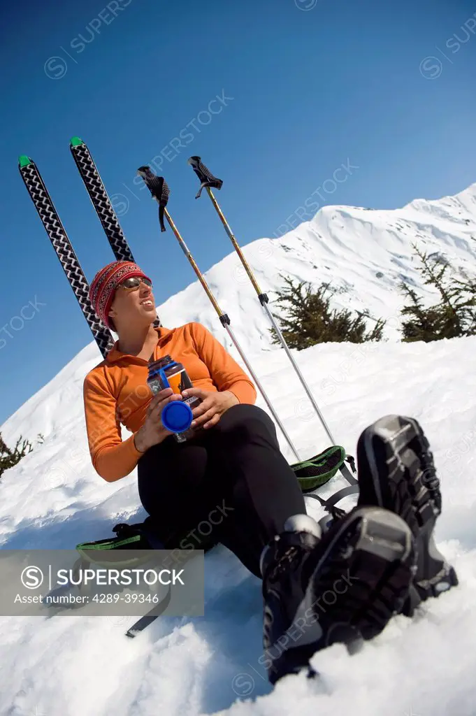 Female Skier Enjoys A Sunny Break During While Ski Touring On Center Ridge In The Turnagain Pass Area Of Chugach National Forest, Alaska
