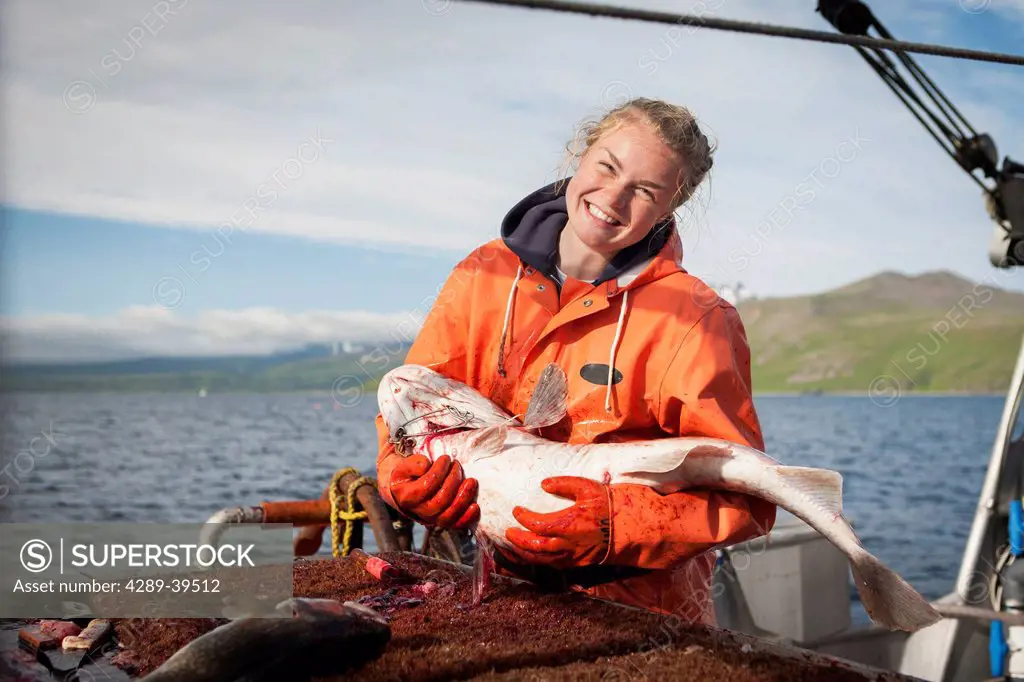 Emma Teal Laukitis embraces a pacific cod caught while commercial longline fishing for pacific halibut near False Pass in Morzhovoi Bay, Southwest Ala...