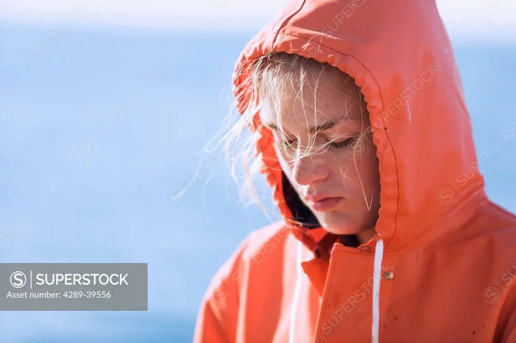 Portrait of Emma Laukitis as she concentrates on baiting commercial halibut longline hooks with pink salmon, Alaska Peninsula, Southwest Alaska, summe...