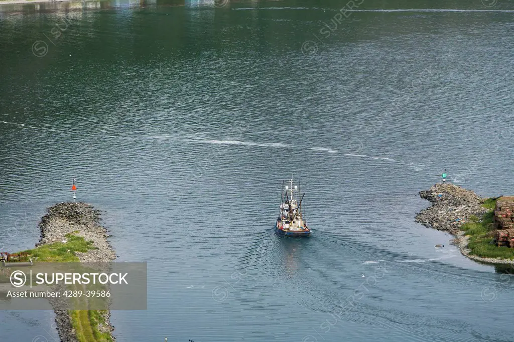 A salmon tender vessel leaving the harbor at King Cove, Alaska Peninsula, Southwest Alaska, summer.