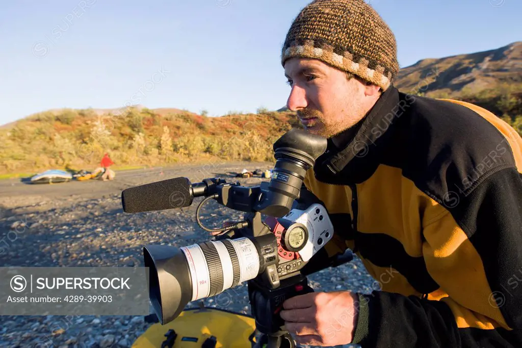 Videographer on Noatak River rafting trip in the Brooks Range, Gates of the Arctic National Park, Northwestern Alaska, above the Arctic Circle, Arctic...