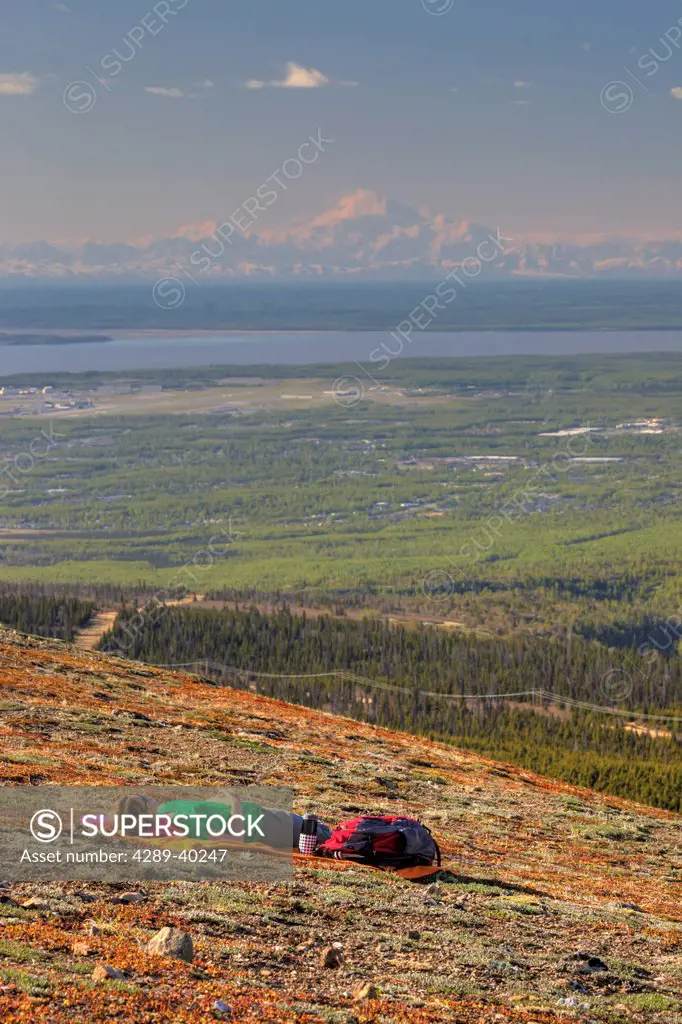 Female hiker resting on Blueberry Hill with Denali (Mt. McKinley) in the distance, Chugach State Park, Anchorage, Southcentral Alaska, Spring, HDR