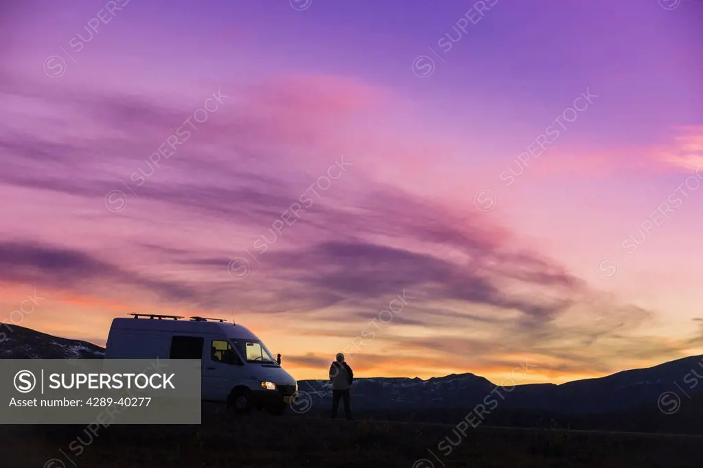 A white Camper van is silhouetted against the sunset above Eagle Summit along the Steese Highway North of Fairbanks fall, Interior Alaska, USA.