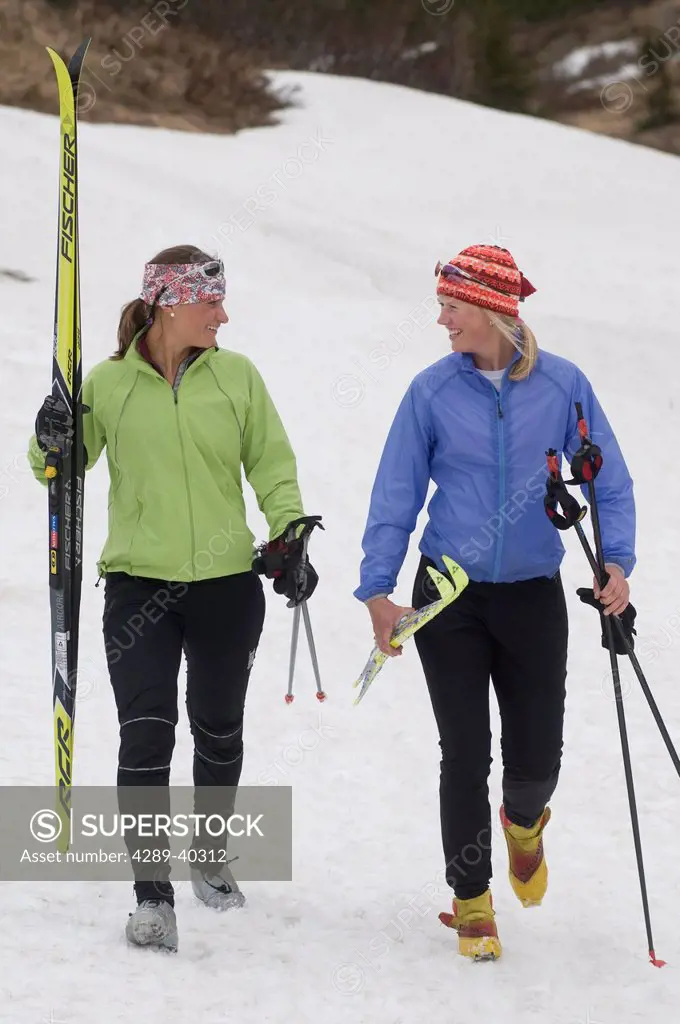 Two Young Women Cross Country Skiing Together At Glen Alps Area In Chugach State Park Near Anchorage, Alaska