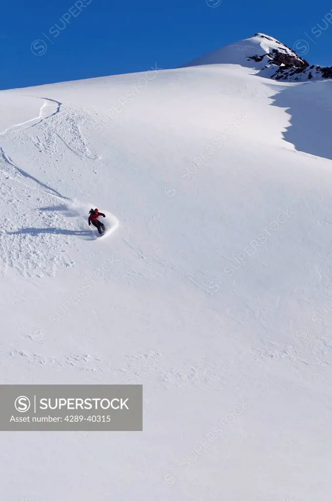 Backcountry Snowboarder Carving Turns Down A Steep Mountain Face, Eagle Glacier, Chugach Mountains, Southcentral, Alaska