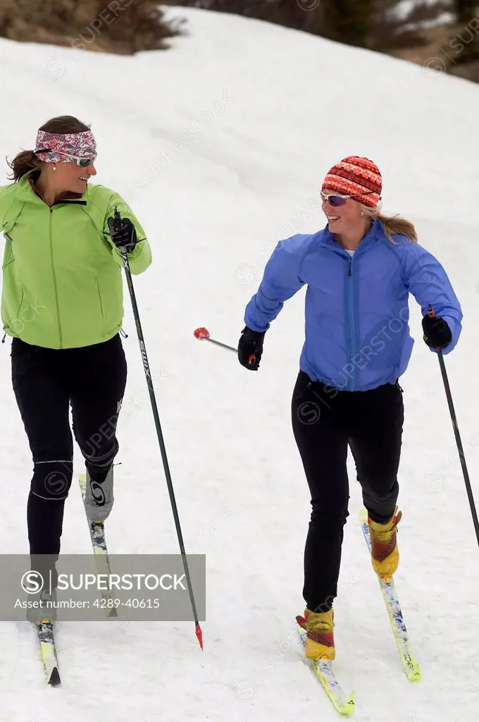 Two Young Women Cross Country Skiing Together At Glen Alps Area In Chugach State Park Near Anchorage, Alaska