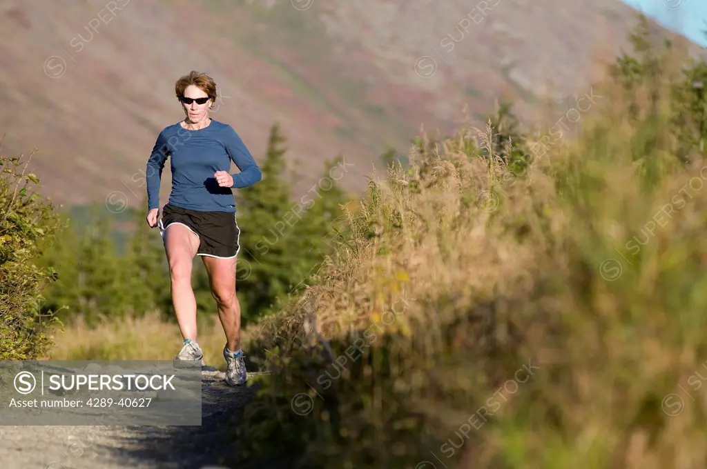 Woman Trail Running In The Glen Alps Area, Chugach Mountains, Anchorage, Southcentral Alaska, Summer