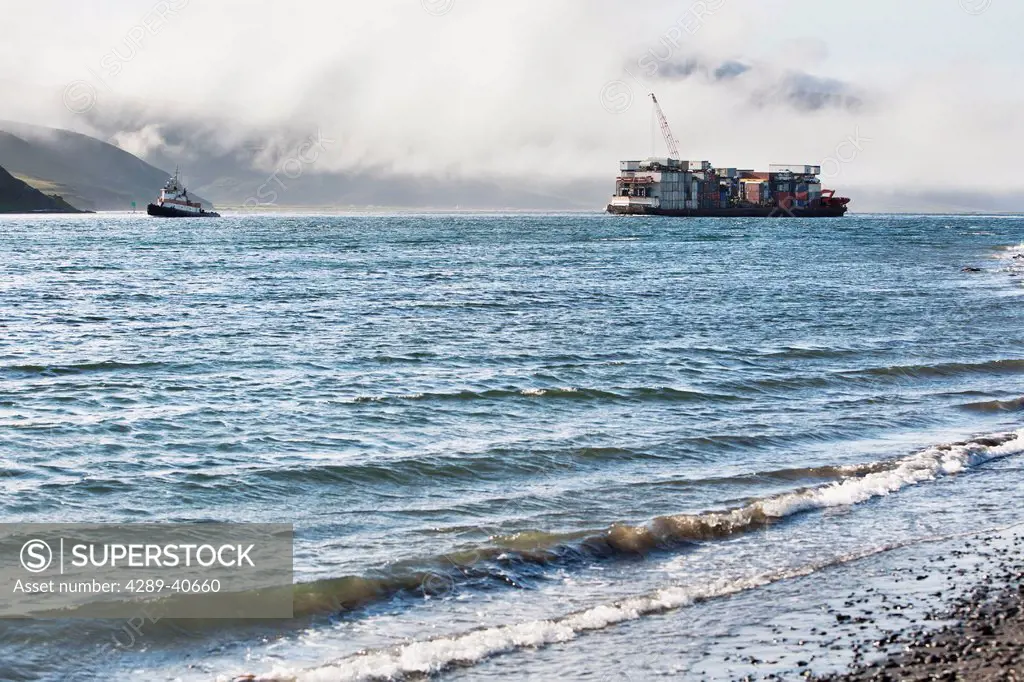A Tug And Barge Heading Through Isanotski Strait, False Pass, Alaska. This Passage Separates The Aleutian Islands From The Alaskan Peninsula And Is Th...