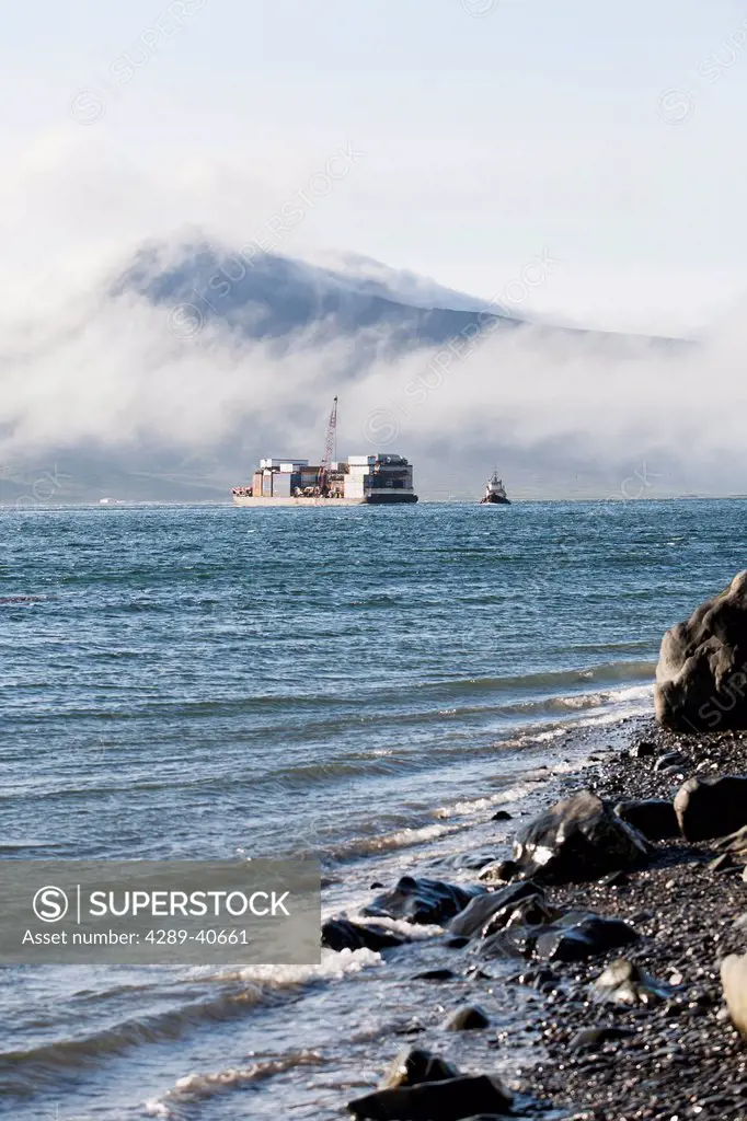 A Tug And Barge Heading Through Isanotski Strait, False Pass, Alaska. This Passage Separates The Aleutian Islands From The Alaskan Peninsula And Is Th...