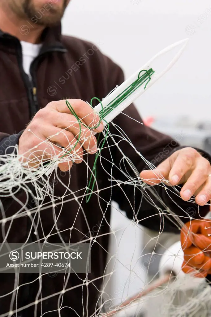 Buck Laukitis And Keith Bell Repair A Tear In Their Gillnet While Commercial Sockeye Salmon Fishing In The Eastern Aleutian Islands, Area M, Region Ab...
