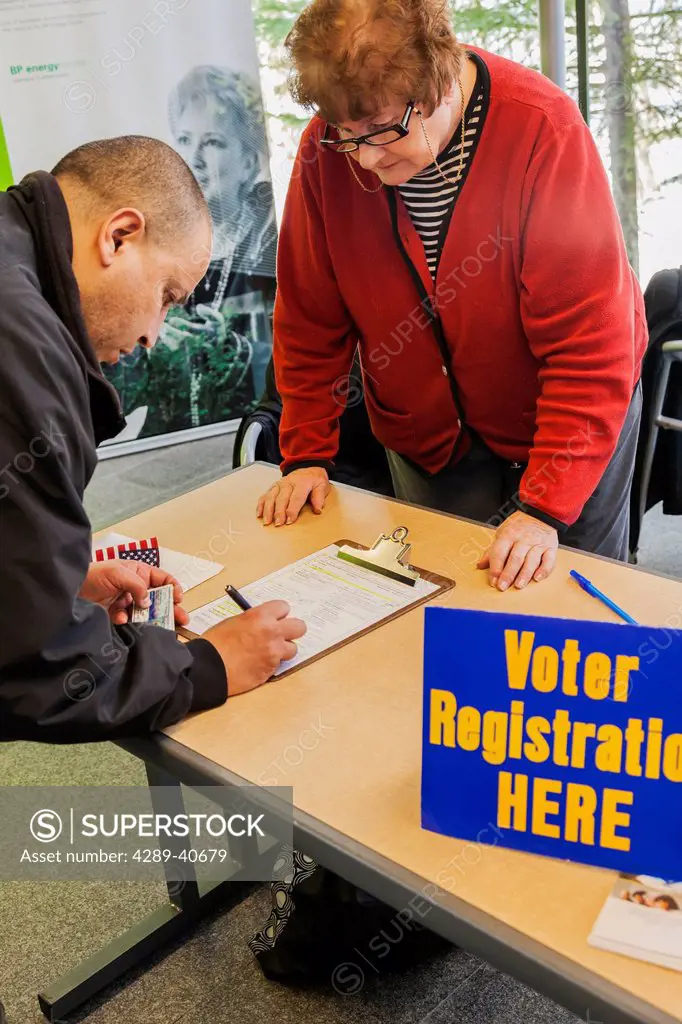 A Woman Volunteer With The League Of Women Voters Helps Register A Man To Vote Who Has Just Become Naturalized Citizens In A Ceremony Held At The Bp E...