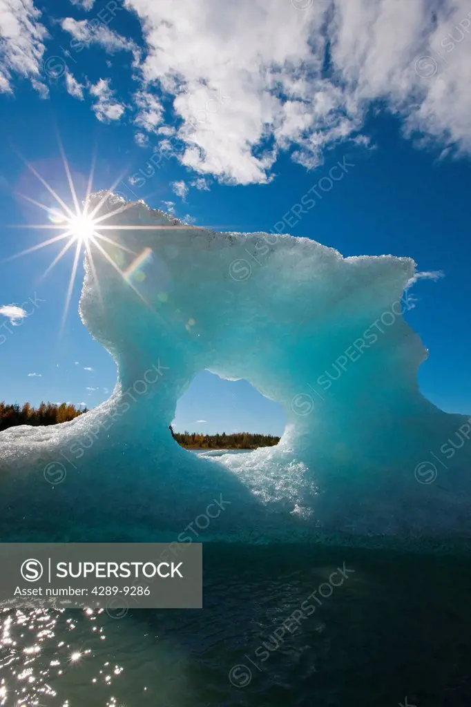 Sunny view of an iceberg in Mendenhall Lake with the sun shining from behind, Southeast Alaska, Summer