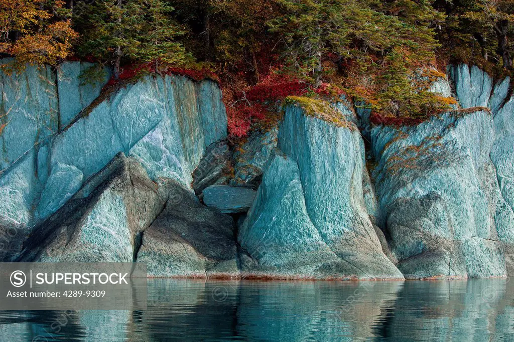 Fall colors line the cliffs along the shoreline of Tracy Arm_Fords Terror Wilderness, Tongass National Forest, Southeast Alaska, Autumn