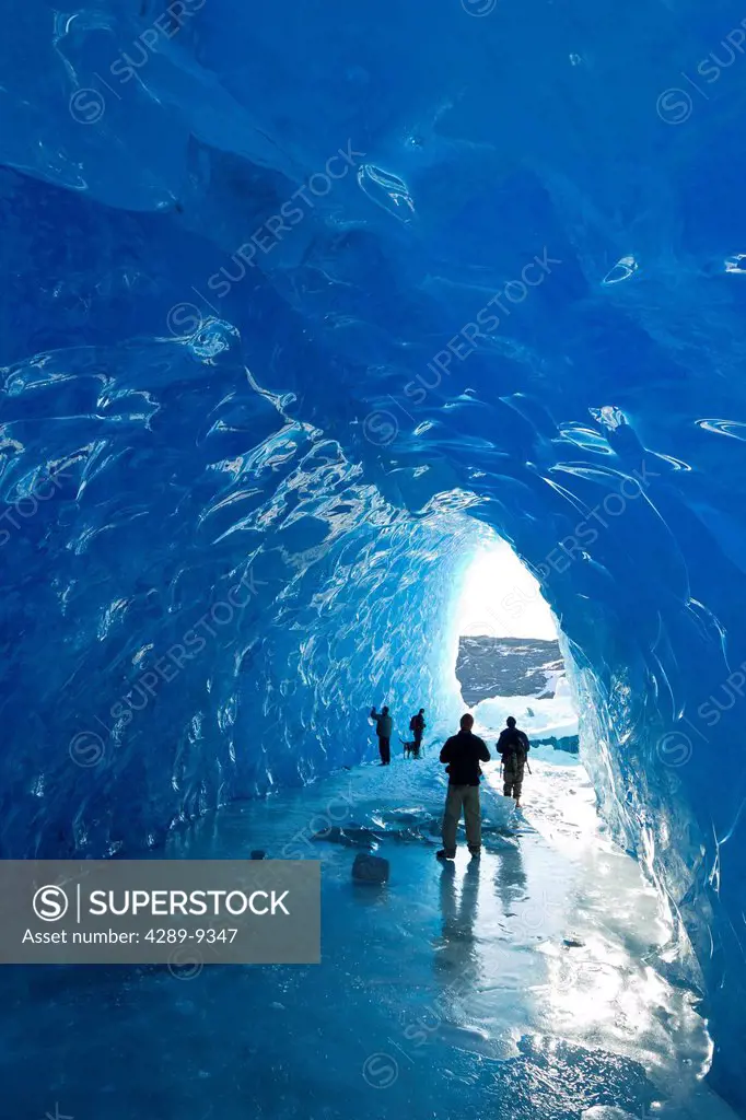 Group of people inside an ice cave of an iceberg frozen in Mendenhall Lake, Juneau, Southeast Alaska, Winter