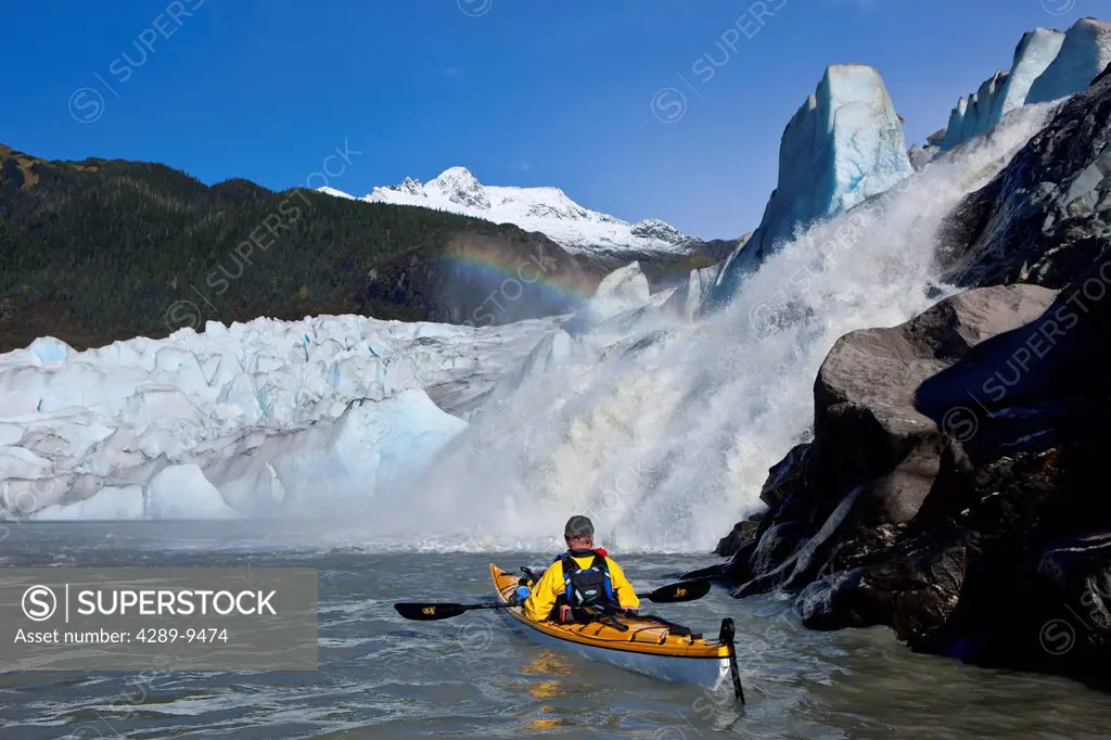 Sea kayaker on Mendenhall Lake with Mendenhall Glacier and Nugget Falls in the background, Southeast Alaska, Summer