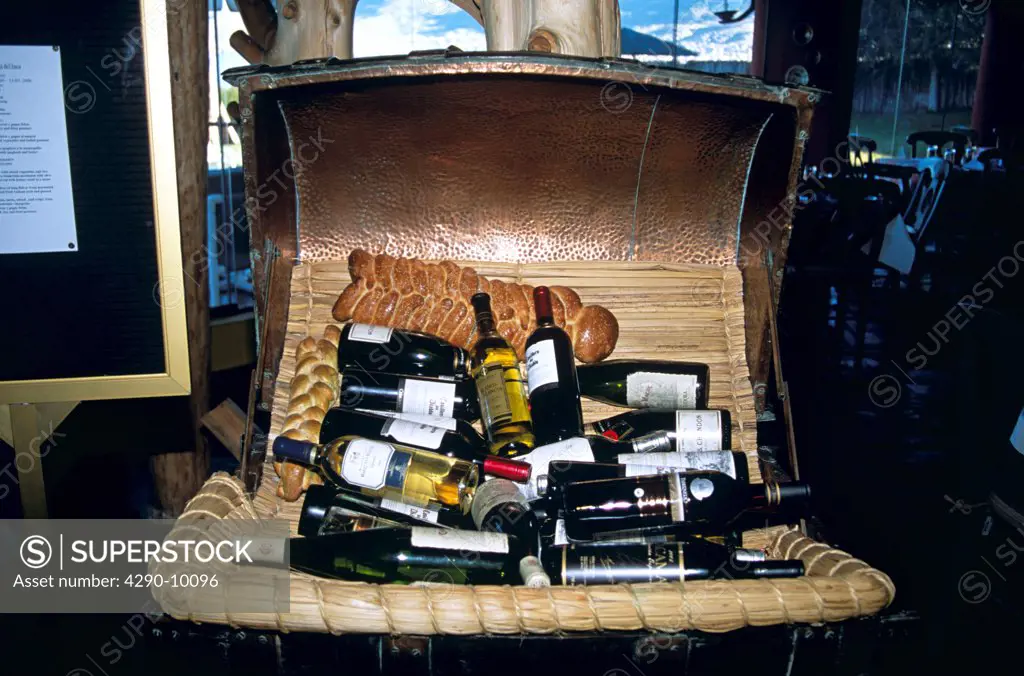 Display of bottles of wine and bread in basket, Puno, Peru