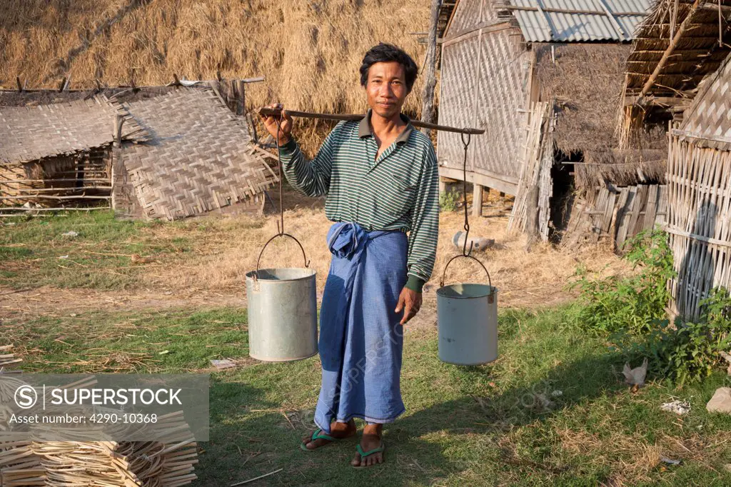 Man carrying pannier for water, Yay Kyi village, Mandalay, Myanmar, (Burma)