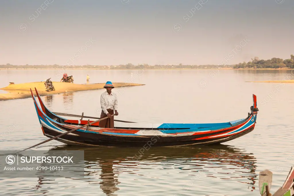 Fisherman rowing his boat on Taungthaman Lake, Amarapura, Mandalay, Myanmar, (Burma)