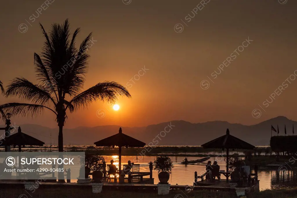 Myanmar, Shan State, Nyaung Shwe, Tourists relaxing during sunset over Inle Lake and Shan Taung Tan mountain