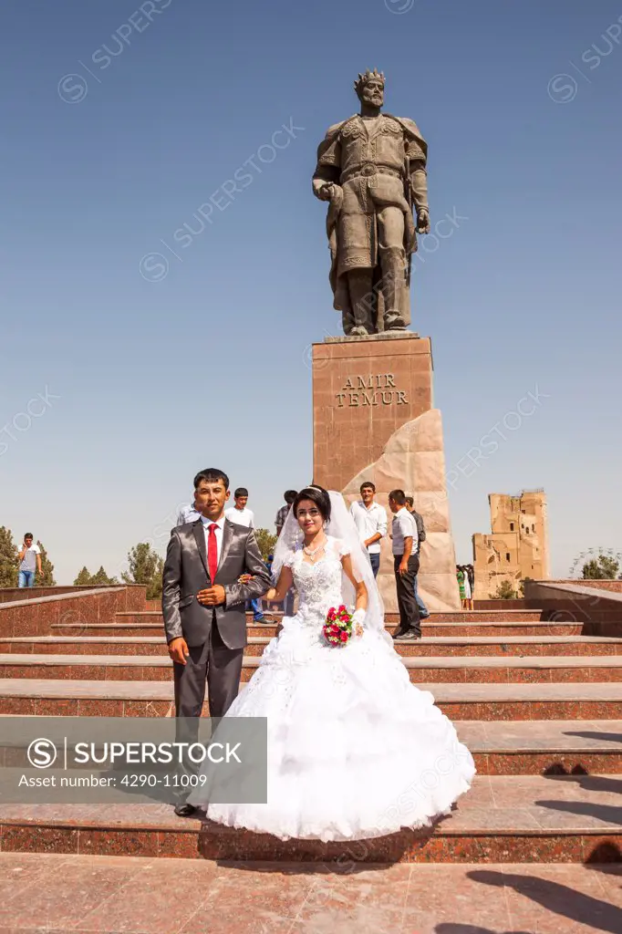 Bride and groom in front of Statue of Amir Timur, also known as Temur and Tamerlane, Shakhrisabz, Uzbekistan