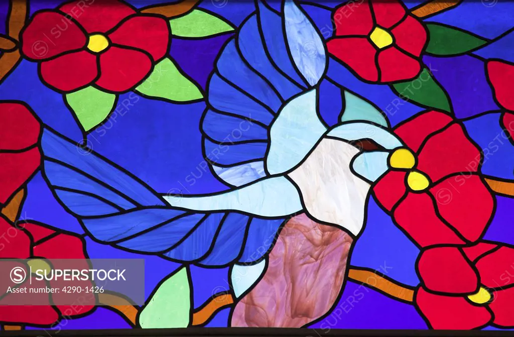 Colourful stained glass window of a bird perched in a tree, Trinidad, Cuba