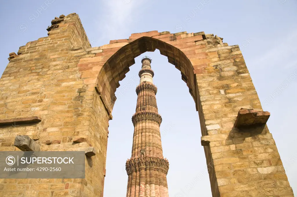 The Qutb Minar minaret, viewed through an arch, in the Qutb Minar Complex, Delhi, India
