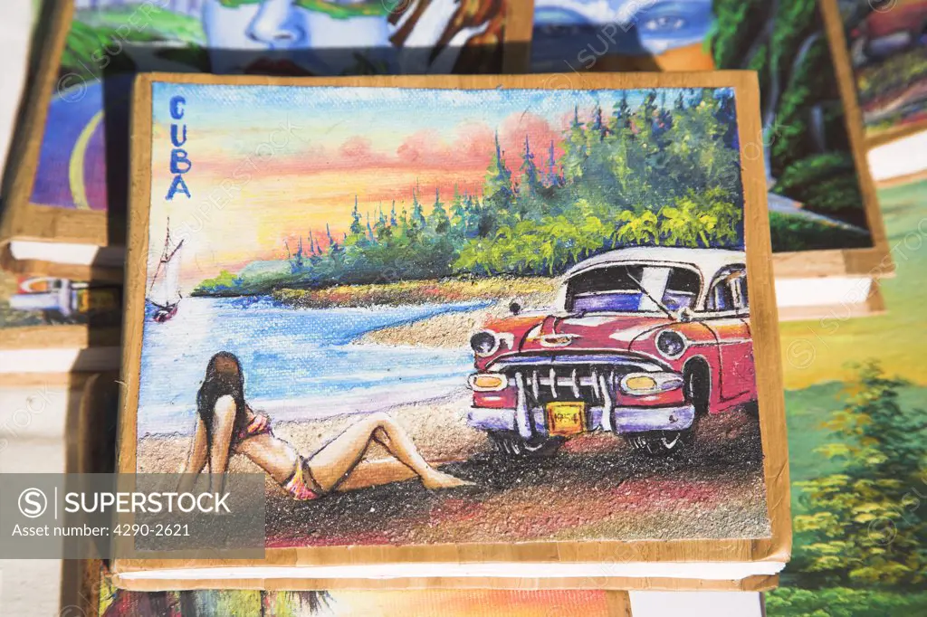Painting of car and woman on photo album on market stall in the Craft Market, Guardalavaca, Holguin Province, Cuba