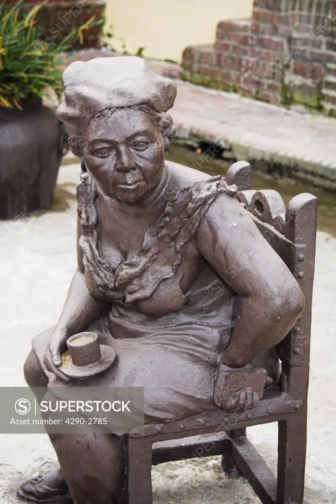 Sculpture of woman seated in a street, holding a cup of tea, Camaguey, Camaguey Province, Cuba