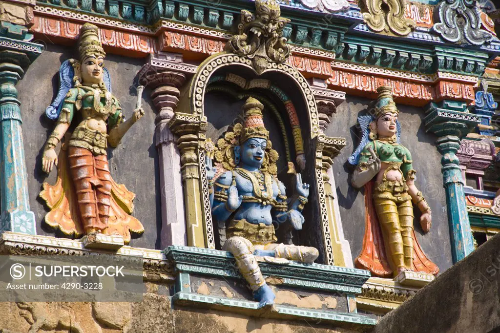 Three carved figures on a gopuram, Meenakshi Temple, Madurai, Tamil Nadu, India