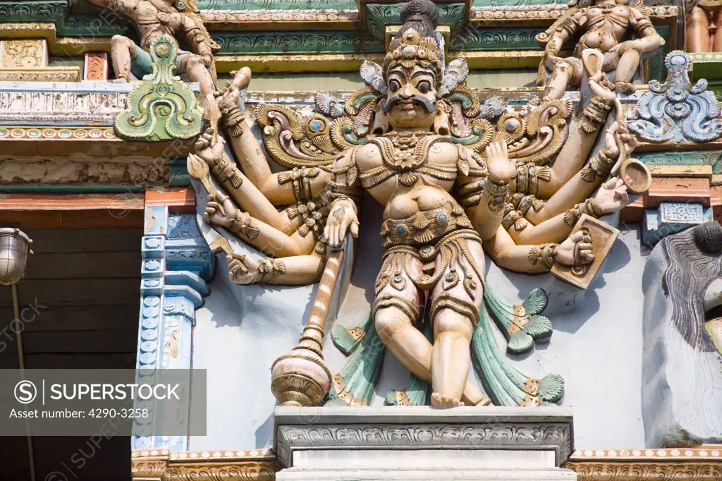 Carved male deity with ten arms on a gopuram, Meenakshi Temple, Madurai, Tamil Nadu, India