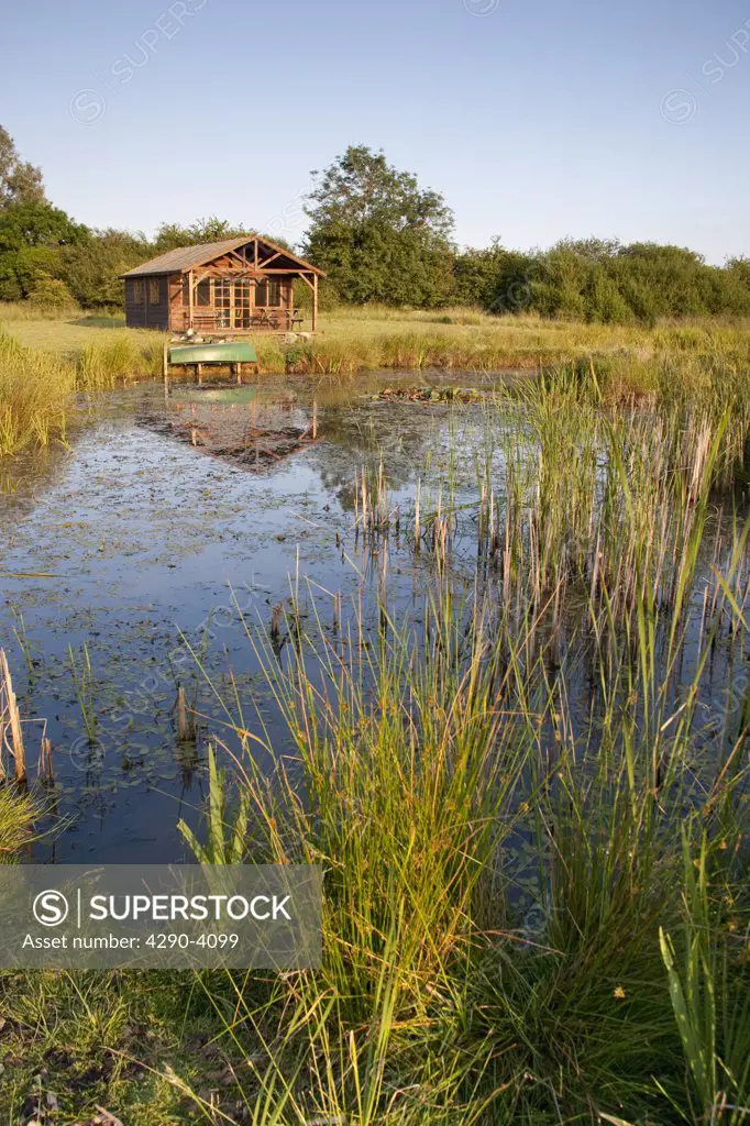 Large pond and summerhouse in the countryside, Wiltshire, England