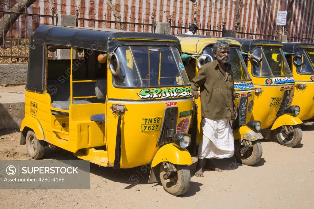 A row of Tuk Tuks parked in a street, and driver, Madurai, Tamil Nadu, India