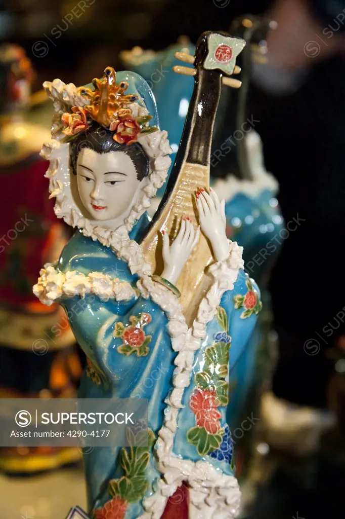 Painted jade carving of a Chinese woman playing a musical instrument, Beijing, China