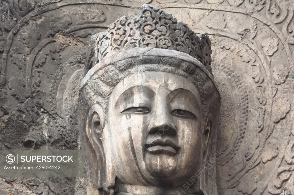 Carved Buddha statue, Fengxian Temple, Longmen Grottoes and Caves, Luoyang, Henan Province, China. Tang Dynasty