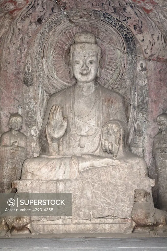 A carved stone Buddha, carved from the rock, Longmen Grottoes and Caves, Luoyang, Henan Province, China