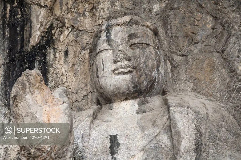 A carved stone Buddha, carved from the rock, Longmen Grottoes and Caves, Luoyang, Henan Province, China