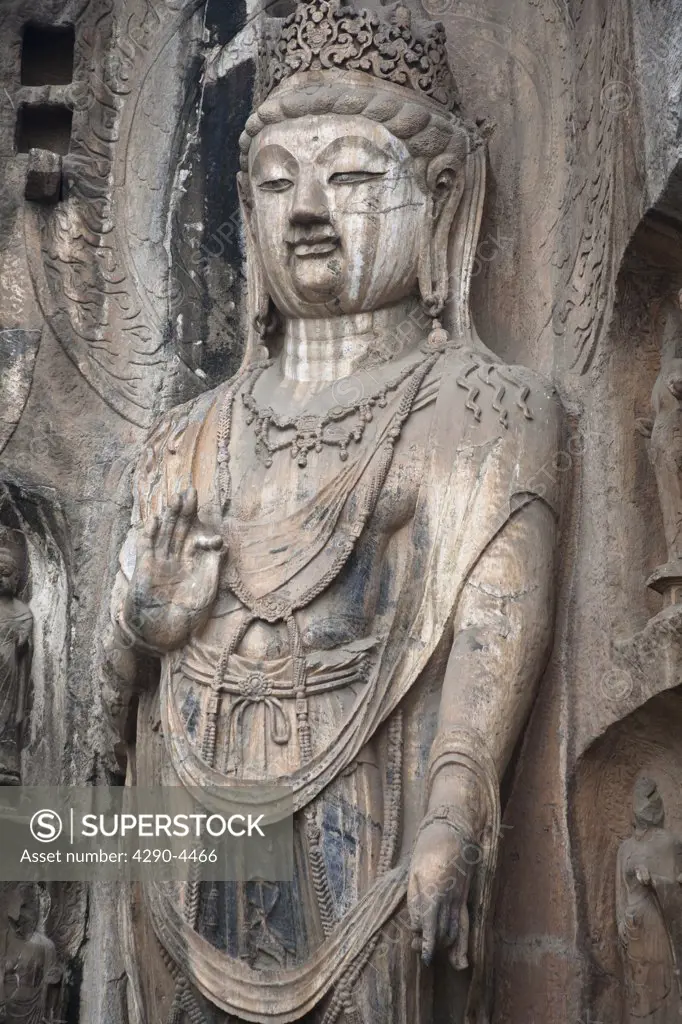 Carved Buddhist statue, Fengxian Temple, Longmen Grottoes and Caves, Luoyang, Henan Province, China. Tang Dynasty