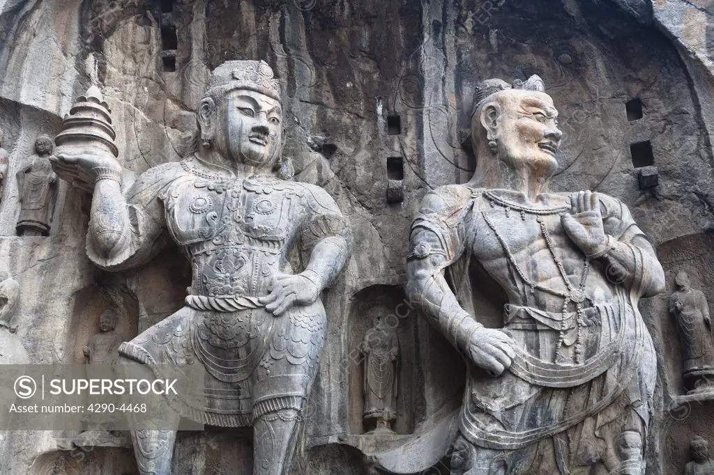 Carved statues, Fengxian Temple, Longmen Grottoes and Caves, Luoyang, Henan Province, China. Tang Dynasty