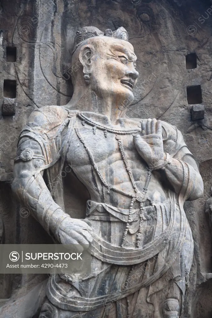 Carved statue, Fengxian Temple, Longmen Grottoes and Caves, Luoyang, Henan Province, China. Tang Dynasty