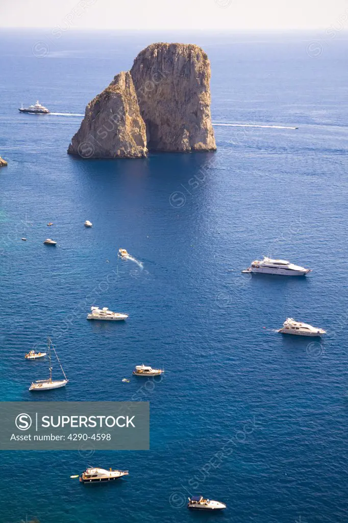 Faraglioni rocks, boats and blue Mediterranean Sea, Capri, Italy