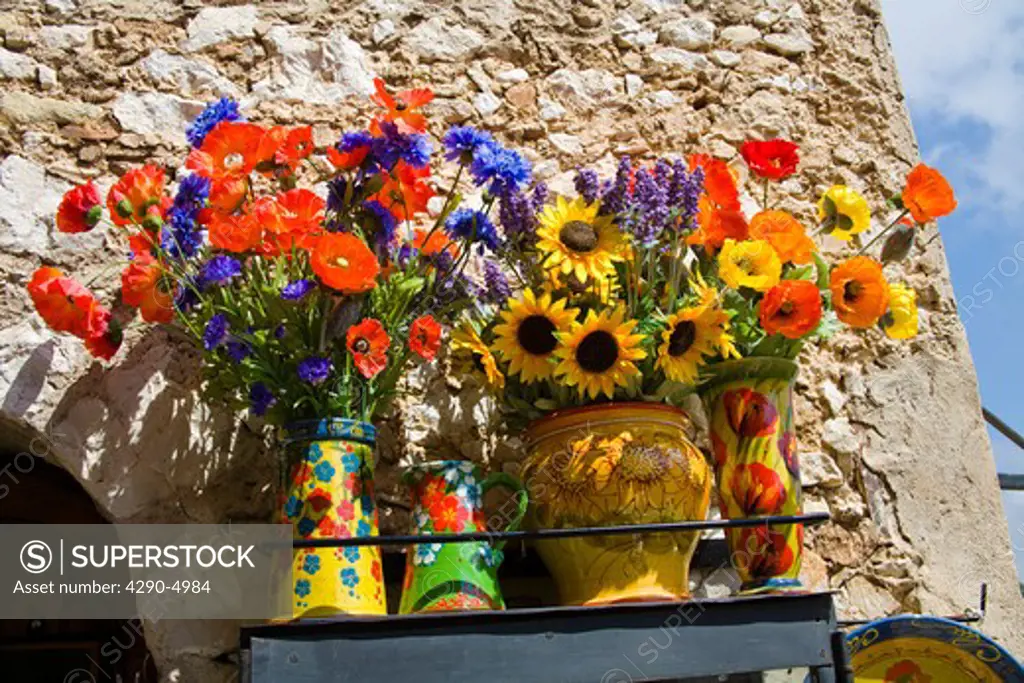 Colourful artificial flowers outside a gift shop in the medieval village of Eze, near Monaco, France