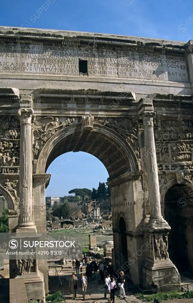 Tourists walking beneath the Arch of Septimius Severus, The Forum, Rome, Italy