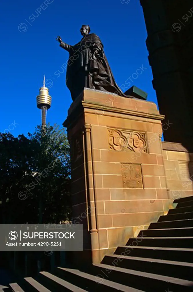 Statue on plinth, Saint Marys Cathedral, and AMP Centrepoint Tower, Sydney, New South Wales, Australia. Evening light