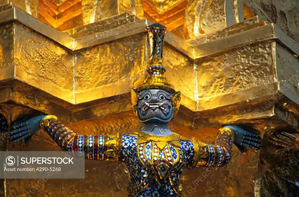 Guardian mythical demon supporting golden chedi, Grand Palace, Bangkok, Thailand